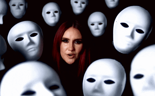 a woman with red hair is surrounded by white masks on a black background