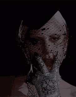 a woman is wearing a veil and gloves and has blood on her face .