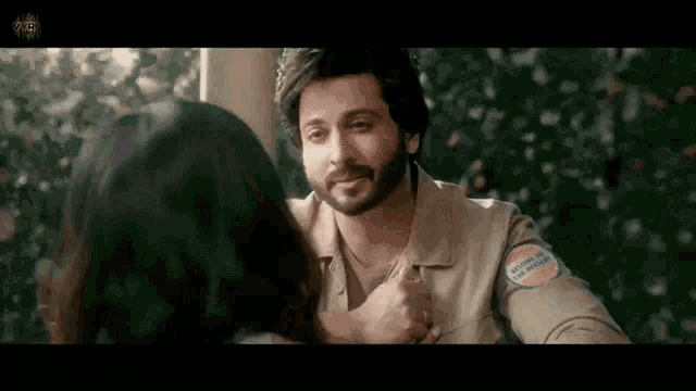 a man with a beard is holding a woman 's hand .
