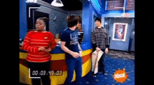 a group of people standing in a room with a nick logo on the bottom