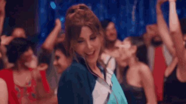 a woman is dancing in front of a crowd of people .
