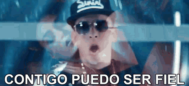 a man wearing sunglasses and a hat with the words contigo puedo ser fiel below him