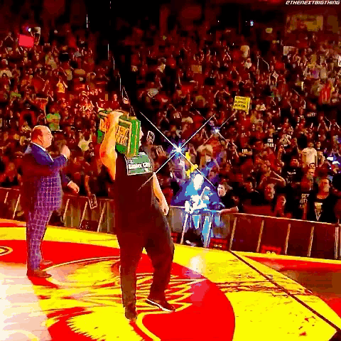 a man is holding a box over his head while walking on a stage .