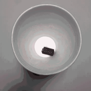 a cup filled with pink liquid and ice cubes