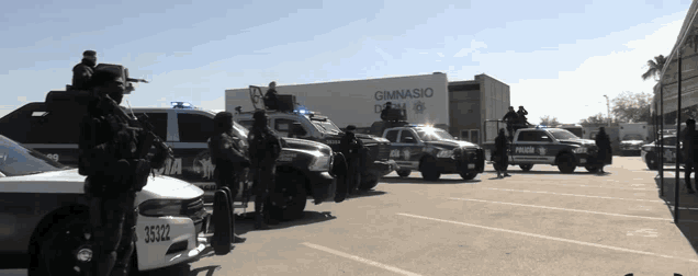 a group of police vehicles are parked in front of a gymnasio