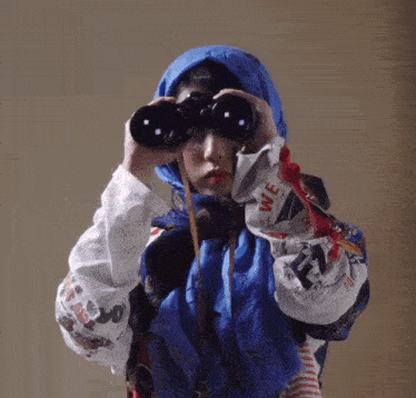 a person looking through binoculars with the word we on the sleeve