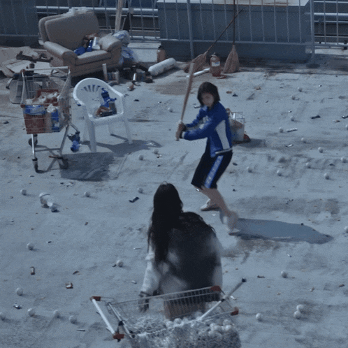 a woman in a blue jacket is throwing a baseball in the air