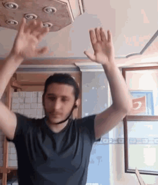 a man is raising his hands in the air while wearing a helmet .