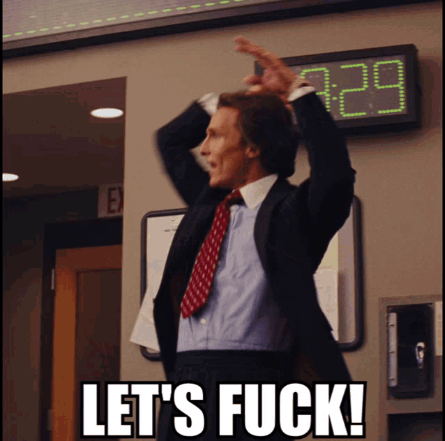 a man in a suit and tie says let 's fuck in front of a display