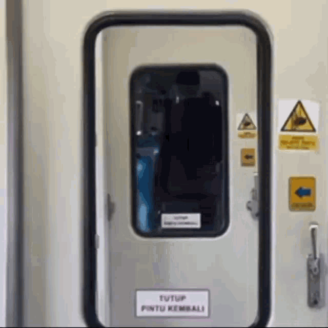 a white door with a sign that says tutup pintu kembali