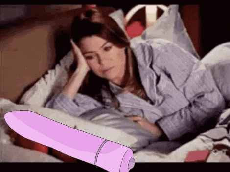 a woman is laying in bed with a purple vibrator .