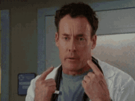 a doctor with a stethoscope around his neck is giving the middle finger