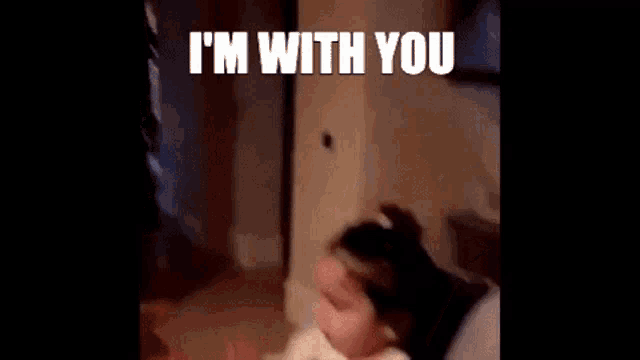 a little girl is sitting in a high chair and giving a high five to a person .