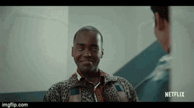 a man in a leopard print shirt is smiling while talking to another man in a netflix ad