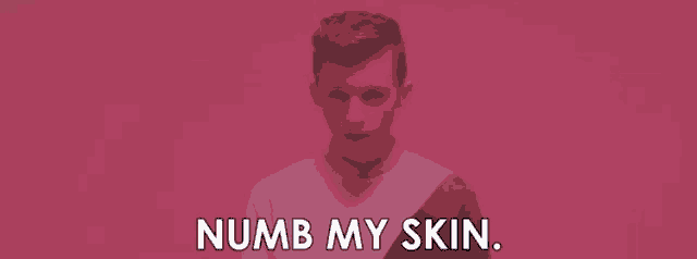 a man in a pink shirt is standing in front of a wall and saying numb my skin .