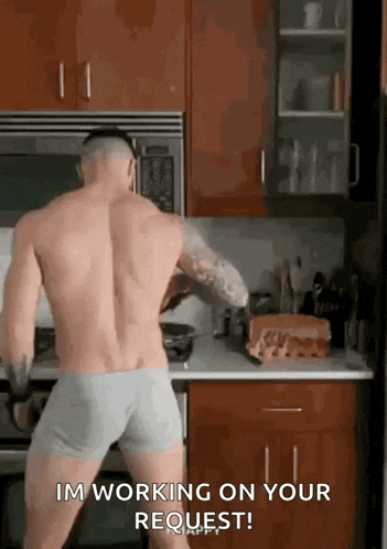 a shirtless man in underwear is dancing in a kitchen while cooking .