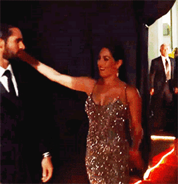 a man in a suit and tie touches a woman 's arm