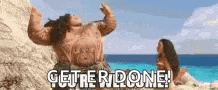 a man is standing on a beach next to a woman and a sign that says `` get 're done ! ''