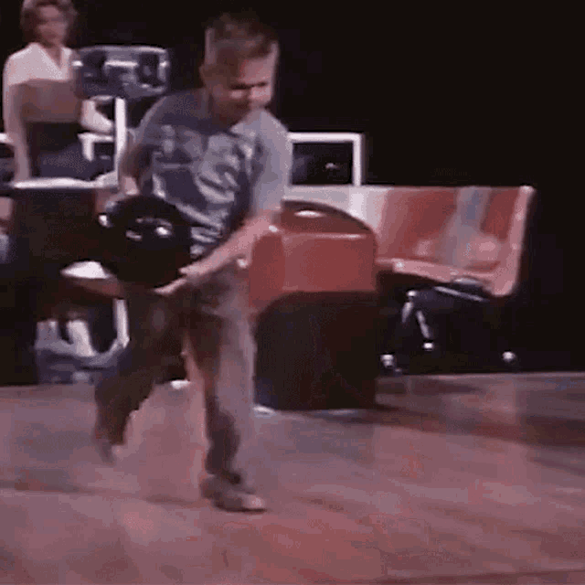 a young boy is playing a game of bowling