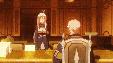 a man sits in a chair while a woman stands at a table