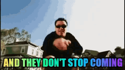 a man is standing in front of a row of houses with the words and they don 't stop
