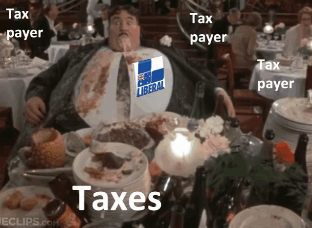 a man sitting at a table with plates of food and a sign that says liberal
