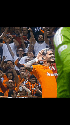 a soccer player wearing an orange shirt that says ' sucu ' on it