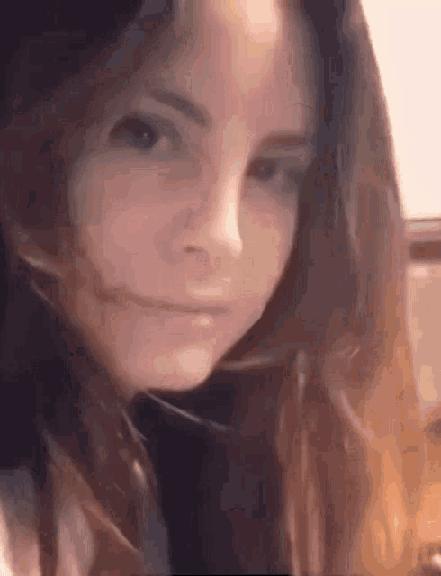 a close up of a woman 's face with long hair making a funny face