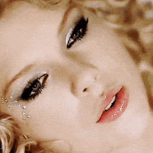 a close up of a woman 's face with makeup and rhinestones