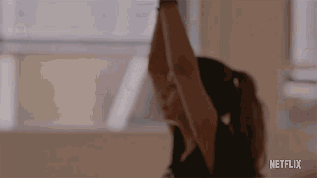 a woman is doing a yoga pose with her arms outstretched in a room .