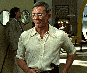a man wearing glasses and a white shirt is holding a glass
