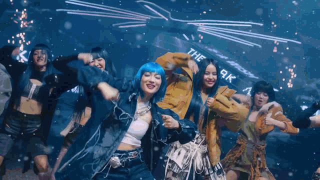 a group of women dancing in front of a sign that says the 9k