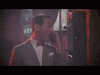 a man in a suit and bow tie talking on a phone