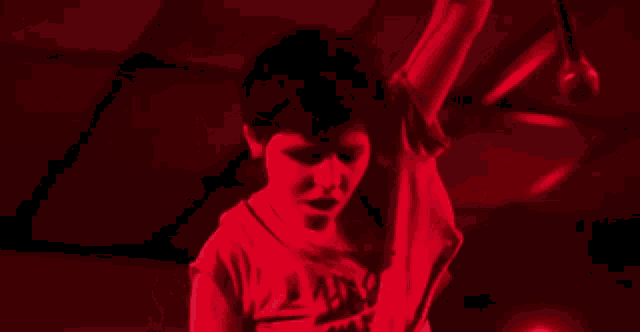 a person in a red shirt is holding a microphone .