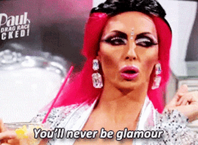 a drag queen says " you 'll never be glamour " while holding a drink