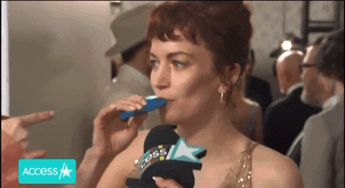 a woman wearing a hat that says access on it is drinking something