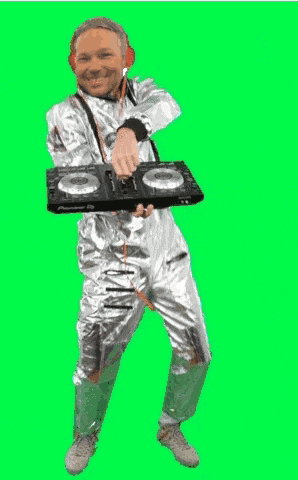 a man in a silver suit is holding a pioneer dj controller