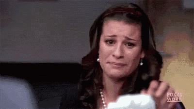 a woman is crying while holding a piece of paper in her hands .