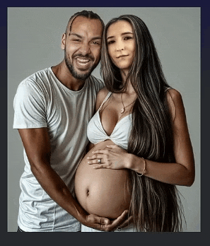 a man and a pregnant woman are posing for a picture together