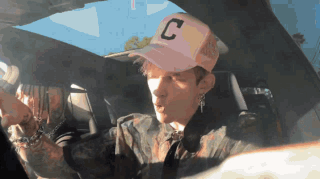 a man wearing a pink hat with a letter c on it