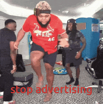 a man wearing a red shirt that says " the lou " is jumping in the air