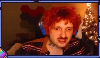 a man with red hair and a mustache is wearing headphones and a red wig .