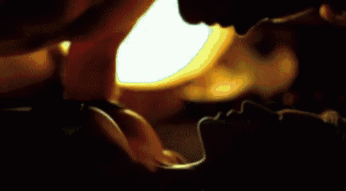a man and woman are kissing in a dark room