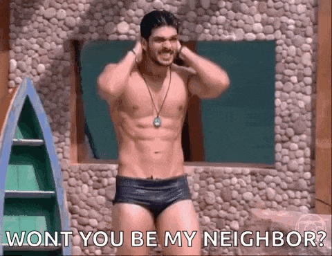 a shirtless man in swim trunks is standing in front of a stone wall and says " wont you be my neighbor " .