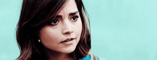 a close up of a woman 's face with a slight smirk on her face .
