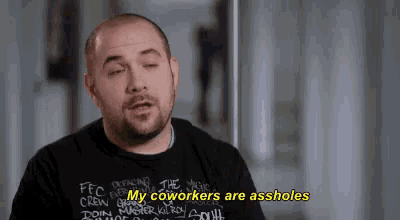 a bald man with a beard is wearing a black shirt that says my coworkers are assholes .