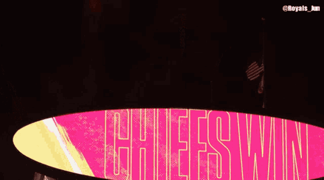 a sign that says ' chiefs win ' on it with fireworks in the background
