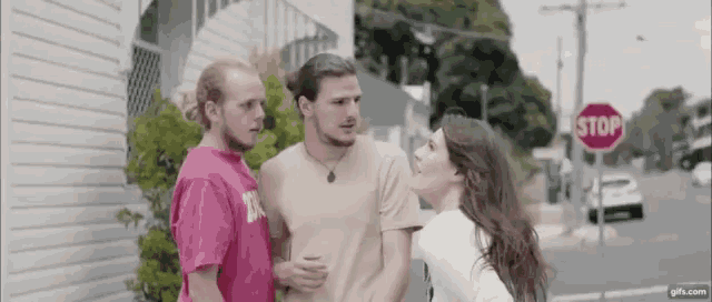 a group of people standing next to each other in front of a stop sign