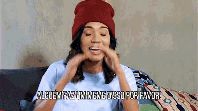 a woman wearing a red hat and a white shirt says alguem faz um meme disso por favor !