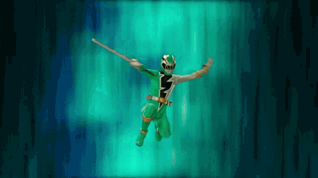 a green power ranger is flying through the air holding a sword